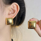 Geometric Square Stud Earrings worn and held up to the ear.