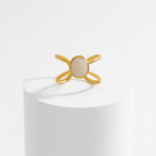 Gold Adjustable Pearl Ring with a central stone on a white pedestal against a white background