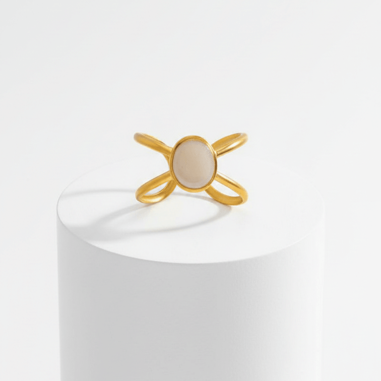 Gold Adjustable Pearl Ring with a central stone on a white pedestal against a white background