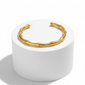 Gold Bamboo Bangle Bracelet on pedestal
