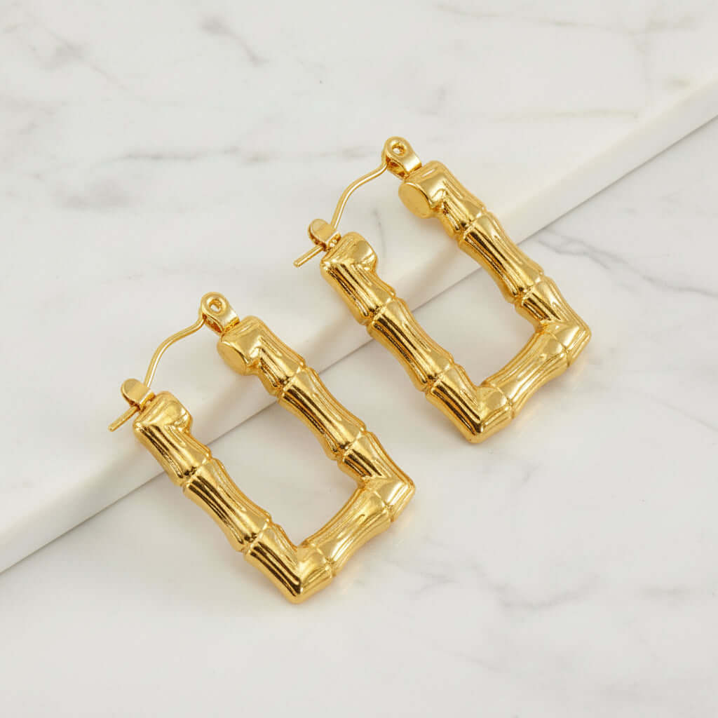Gold Bamboo Rectangular Hoop Earrings on white stone