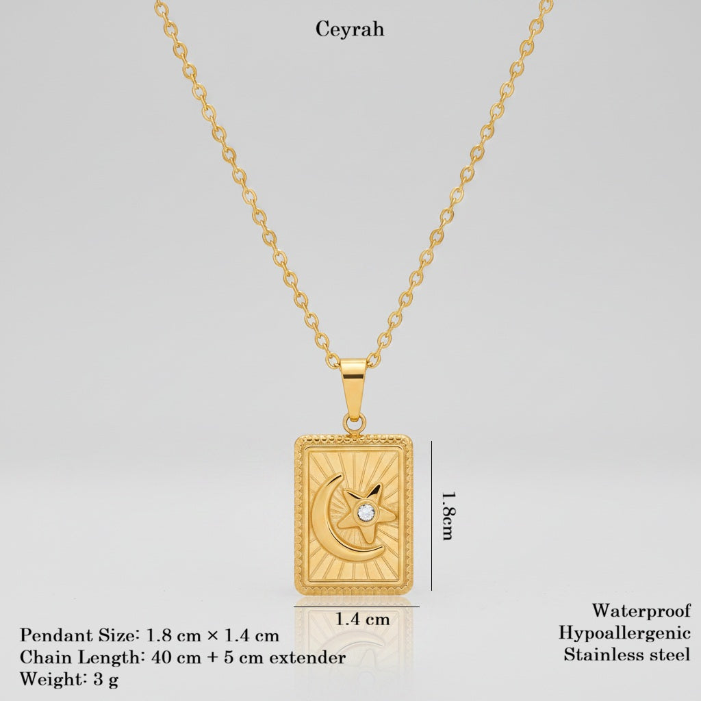 Gold pendant necklace on a light gray background with text showing product details and dimensions. The pendant is rectangular with a crescent moon and star design and a small clear stone, labeled 'Ceyrah.
