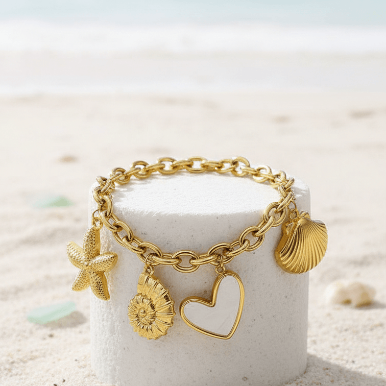 Gold Coastal Charm Bracelet on a white cylindrical container with a beach background