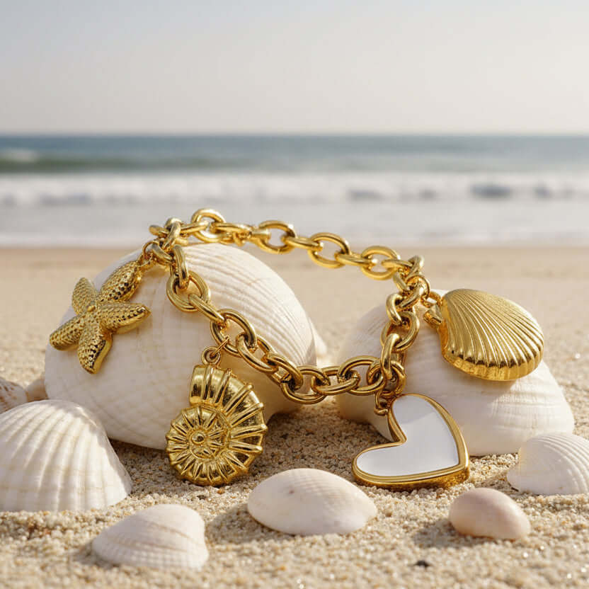Gold charm bracelet with various charms on a textured stone surface