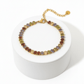 Gold Colour Gemstone Bracelet featuring jewel-tone beads and a polished gold chain on a display box.