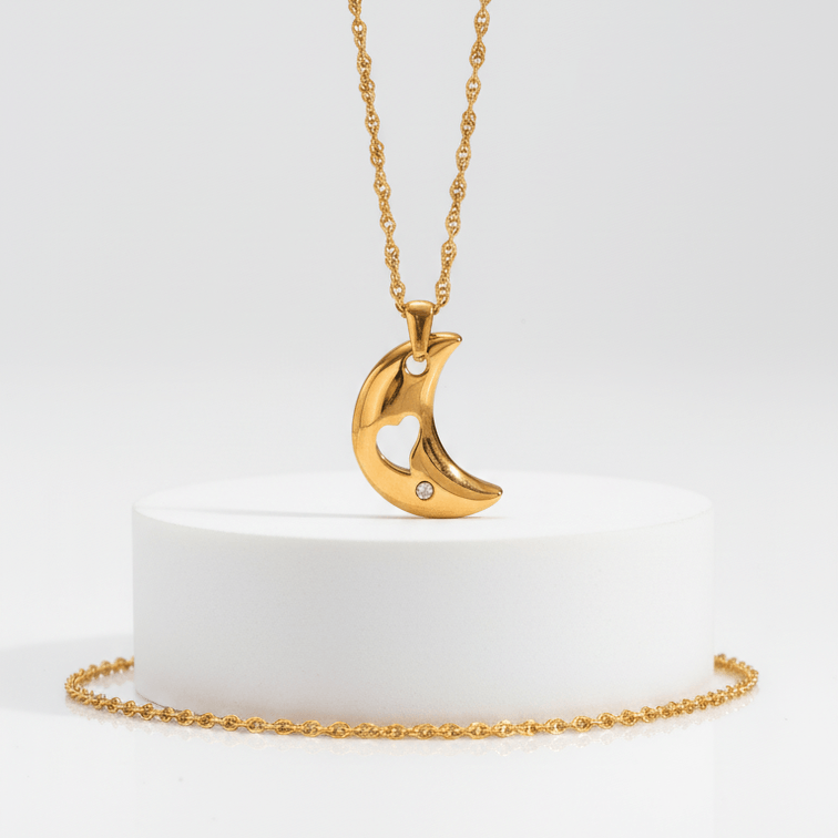 Gold necklace with a crescent moon pendant on a white background