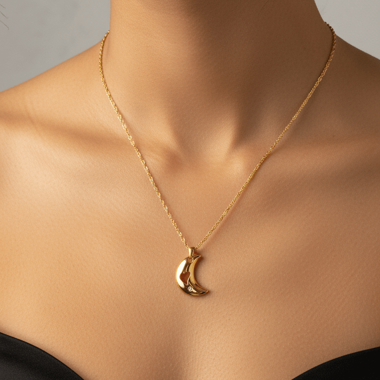 Close-up of a woman wearing a gold necklace with a crescent moon pendant on a neutral background.
