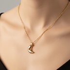 Gold necklace with a crescent moon pendant on a neutral background