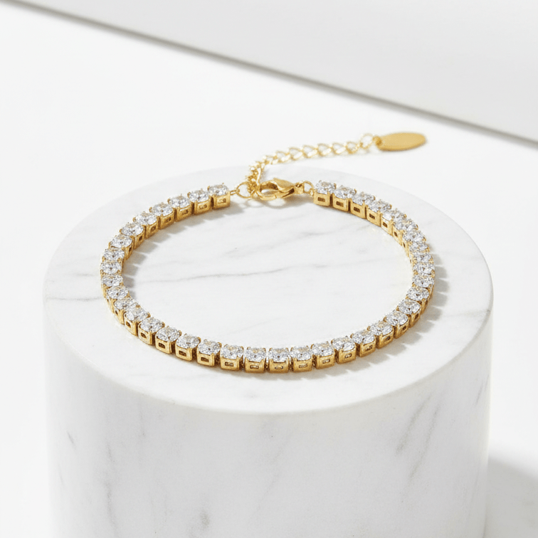 Gold Crystal Tennis Classic Bracelet with clear stones on a white marble surface