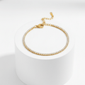 Gold Crystal Tennis Mini Bracelet on a white cylindrical stand with a white background