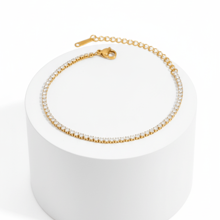 Gold Crystal Tennis Mini Bracelet on a white cylindrical stand with a white background