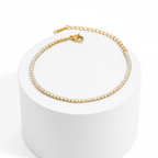 Gold Crystal Tennis Mini Bracelet on a white cylindrical stand with a white background