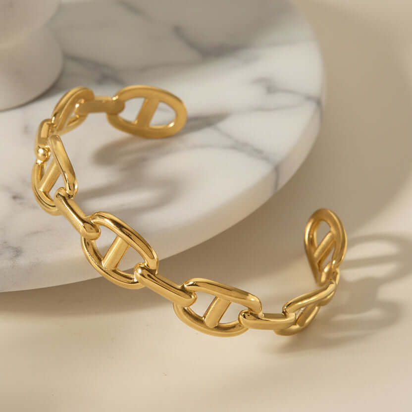 Gold D Link Chain Bracelet on surface next to marble plate