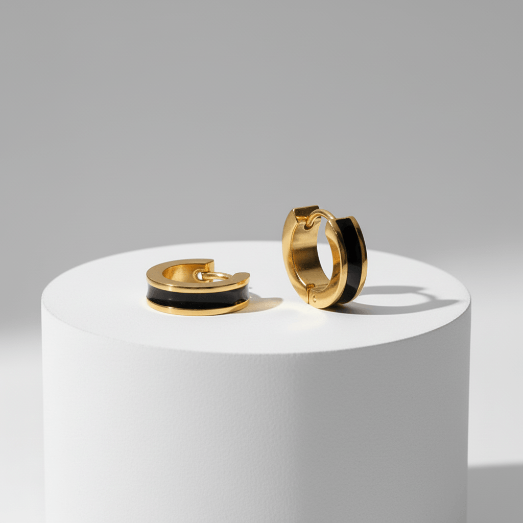 Gold Enamel Huggie Hoop Earrings with black interior on a white platform against a gray background