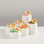 Set of Gold Enamel Huggie Hoop Earrings with colorful bands on a white background