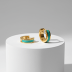 Gold Enamel Huggie Hoop Earrings with turquoise enamel on a white platform against a gray background