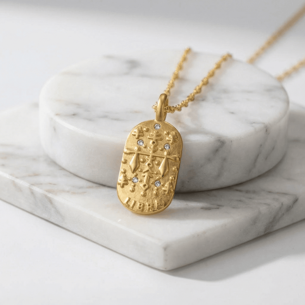Libra Gold Engraved Zodiac Sign Necklace on a marble surface