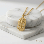 Aries Gold Engraved Zodiac Sign Necklace on a marble surface