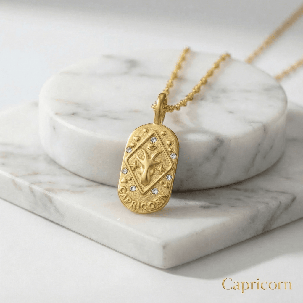 Capricorn Gold Engraved Zodiac Sign Necklace on a marble surface