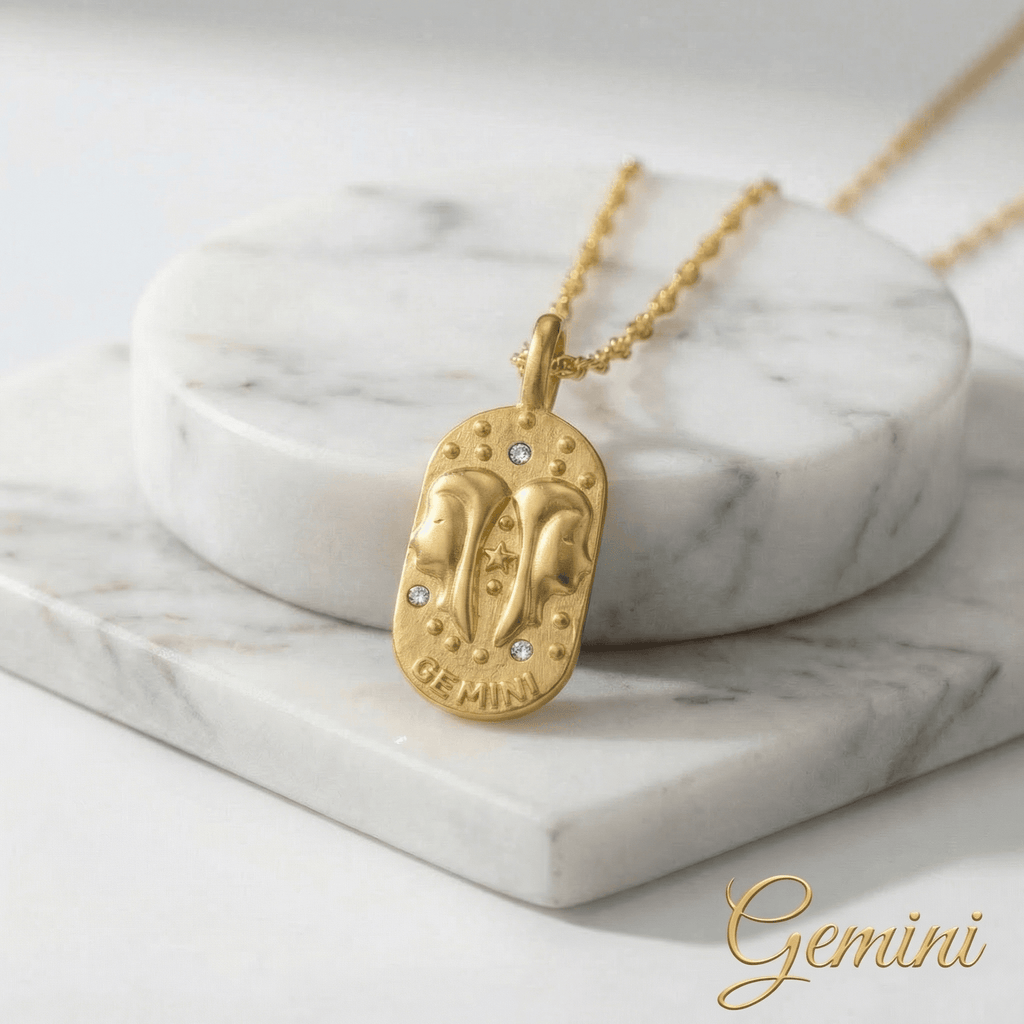 Gemini Gold Engraved Zodiac Sign Necklace on a marble surface