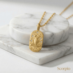 Scorpio Gold Engraved Zodiac Sign Necklace necklace on a marble surface