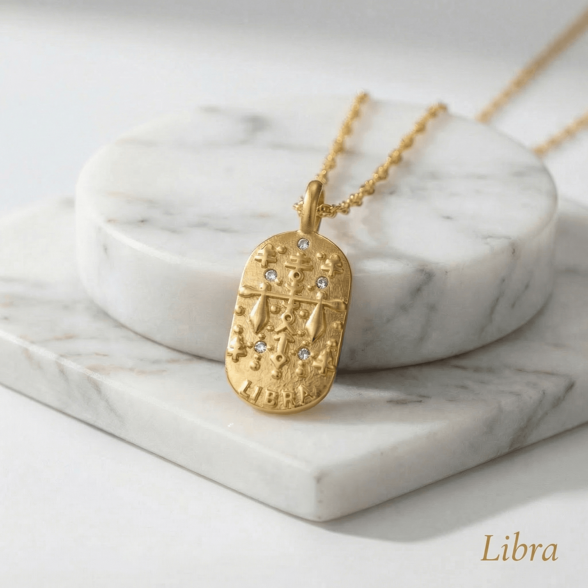 Libra Gold Engraved Zodiac Sign Necklace on a marble surface with 'Libra' text