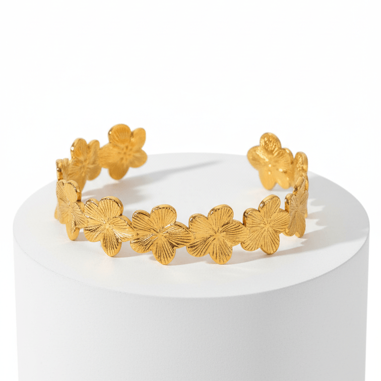 Gold Floral Cuff Bracelet on white pedestal