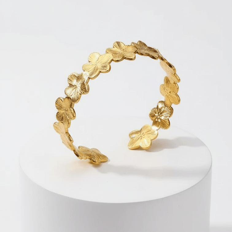 Gold Floral Cuff Bracelet on white pedestal