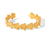 Gold Floral Cuff Bracelet with floral designs on a white background