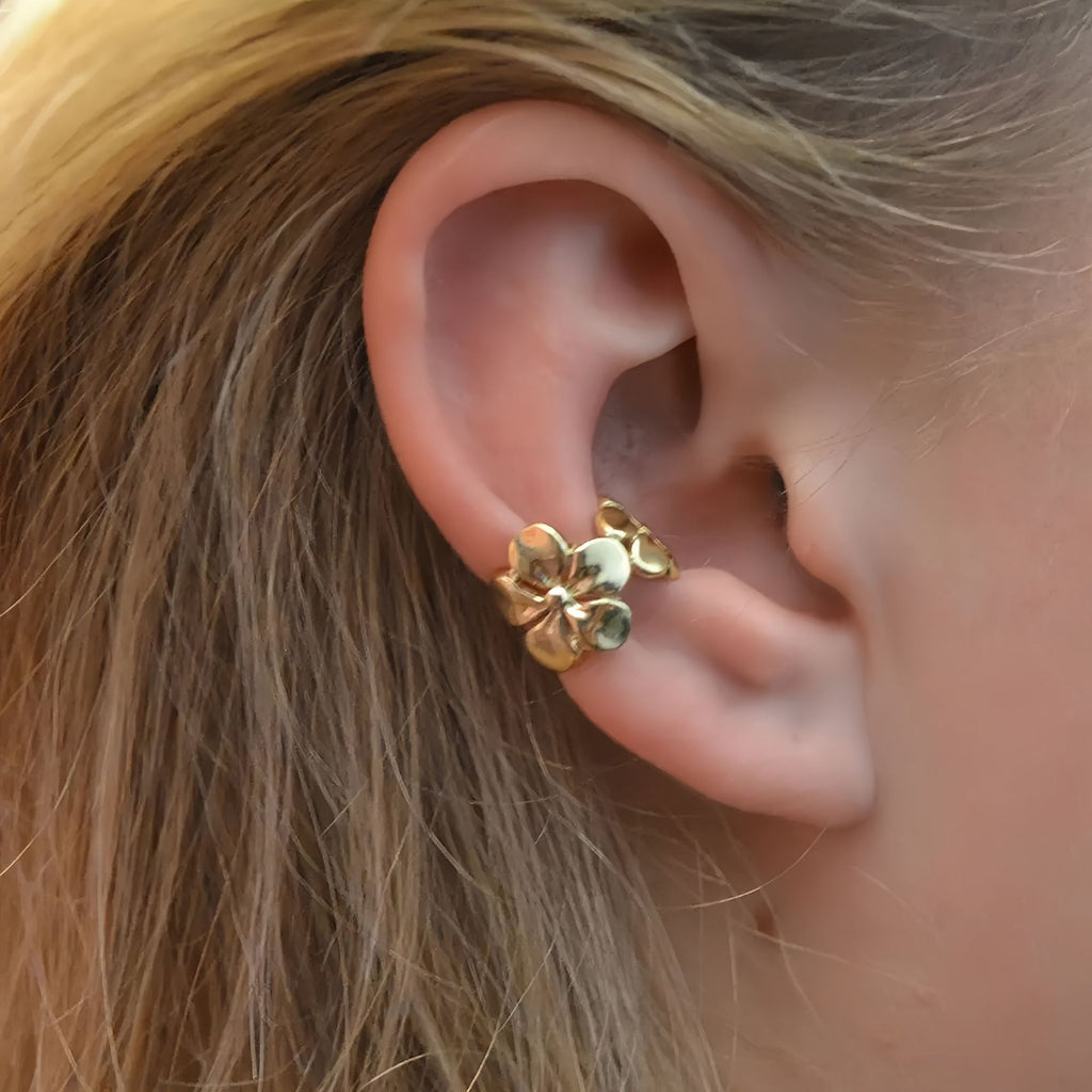 Gold Floral Ear Cuff Set worn on a person's ear with blonde hair.