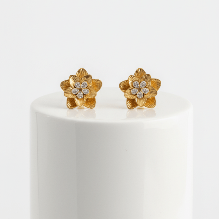 Pair of Gold Floral Shaped Stud Earrings on a white pedestal against a white background