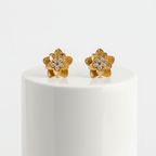 Pair of Gold Floral Shaped Stud Earrings on a white pedestal against a white background