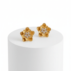 Gold Floral Shaped Stud Earrings on a white pedestal with a white background