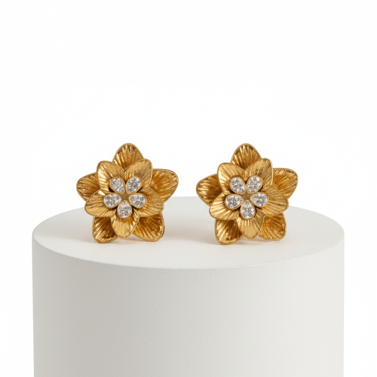 Gold Floral Shaped Stud Earrings on a white pedestal against a white background