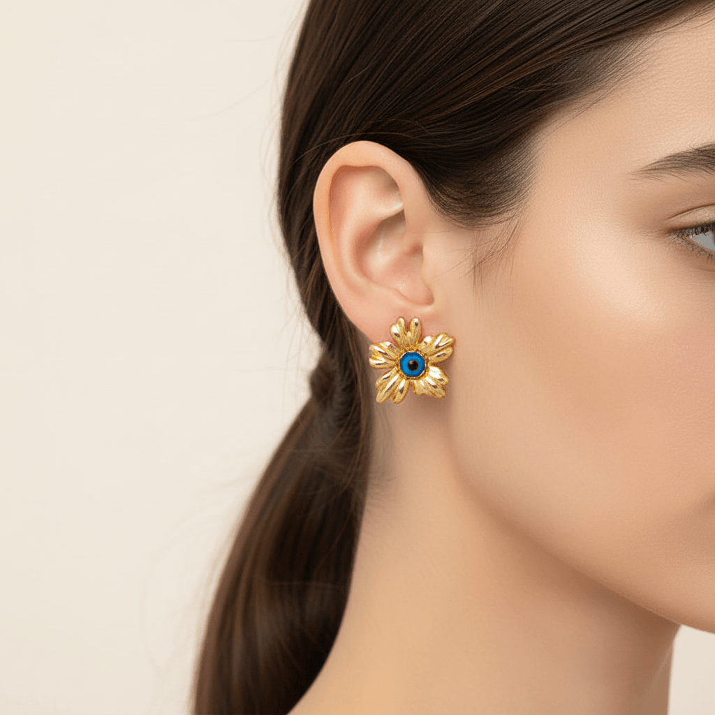 Close-up of a model wearing gold floral stud earrings with blue stone, highlighting the artisanal design and elegance.
