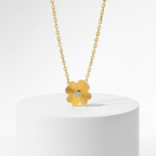 Gold Flower Pendant Necklace with a flower-shaped pendant on a white pedestal against a light gray background