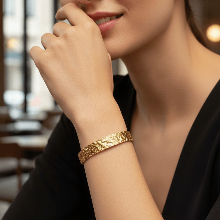 Woman wearing a Gold Hammered Cuff Bracelet with a blurred indoor background
