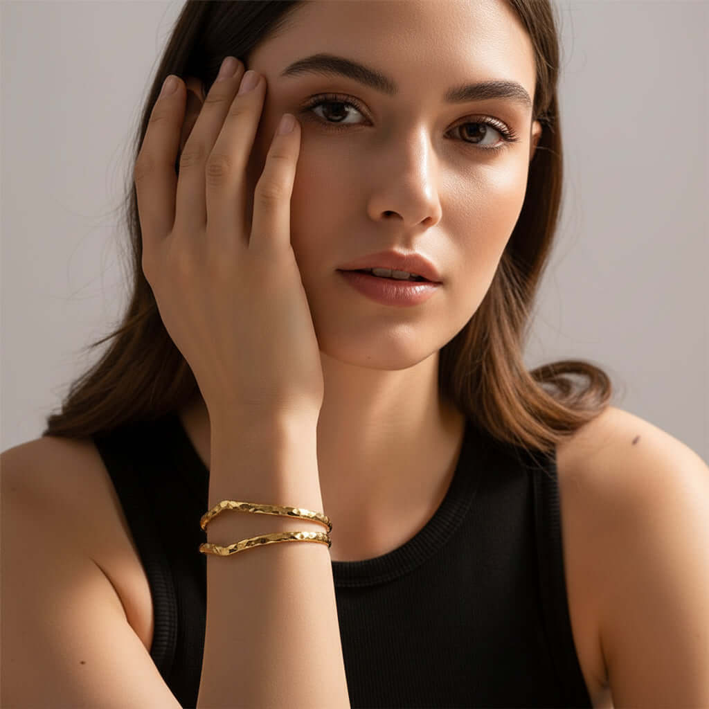 Gold Hammered Wave Cuff Bracelet on a person's wrist with a neutral background