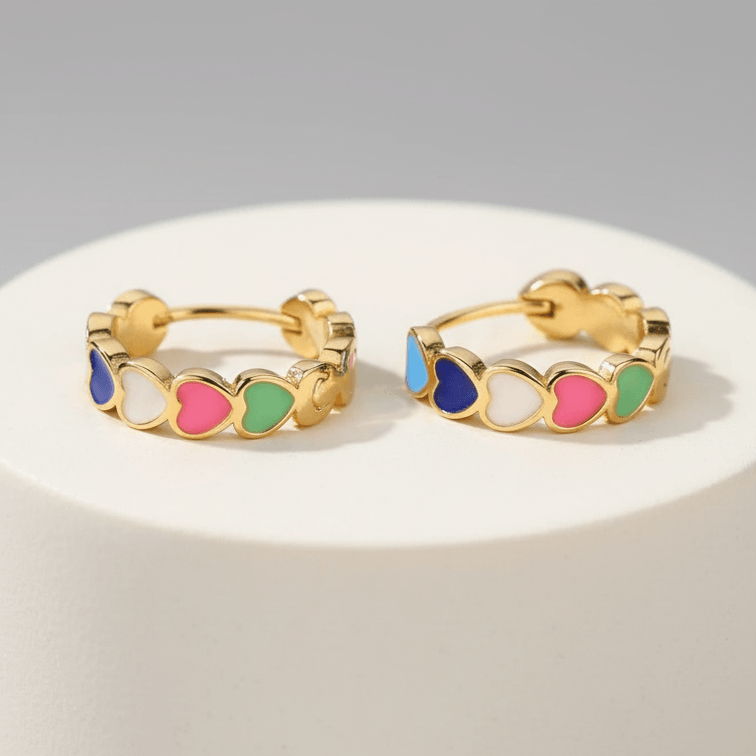 Gold Heart Charm Hoop Earrings with colorful circular accents on a white stand against a gray background