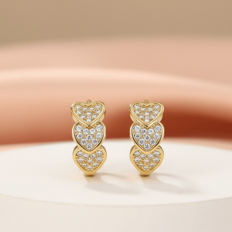 Gold Heart Crystal Cluster Hoop Earrings on a beige background