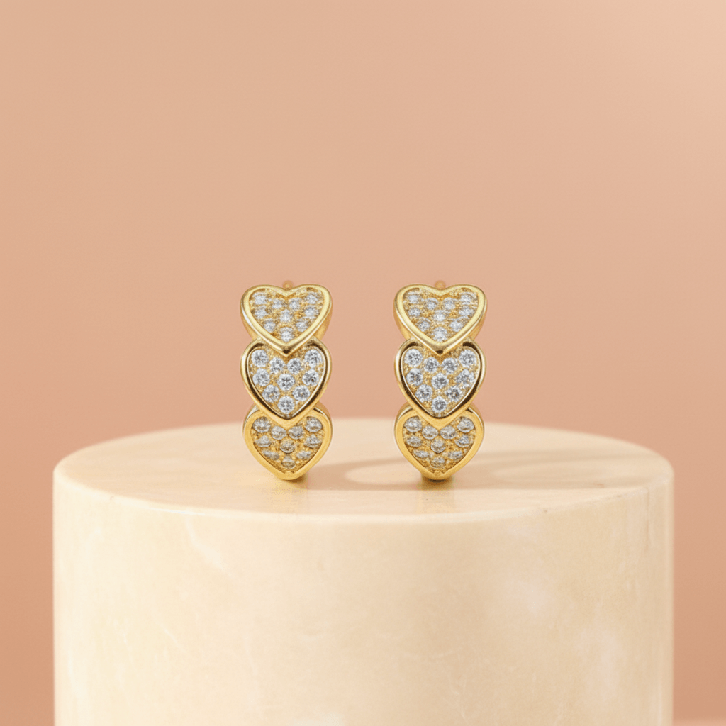 Gold Heart Crystal Cluster Hoop Earrings on a beige stand with a beige background