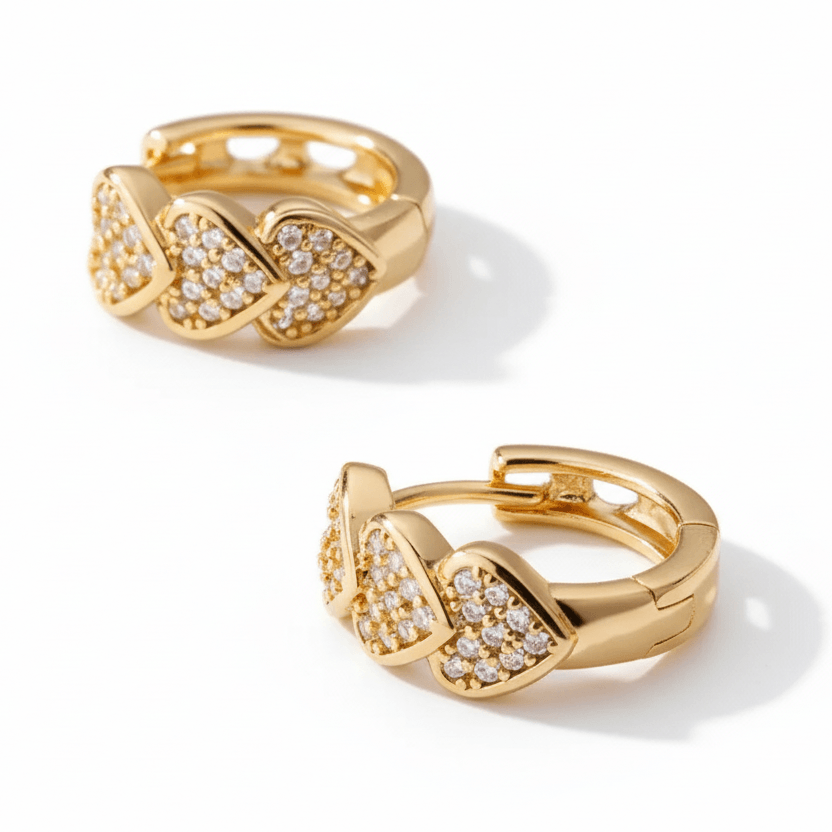 Pair of gold hoop earrings with diamond accents on a beige fabric background