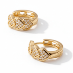 Pair of gold hoop earrings with diamond accents on a beige fabric background
