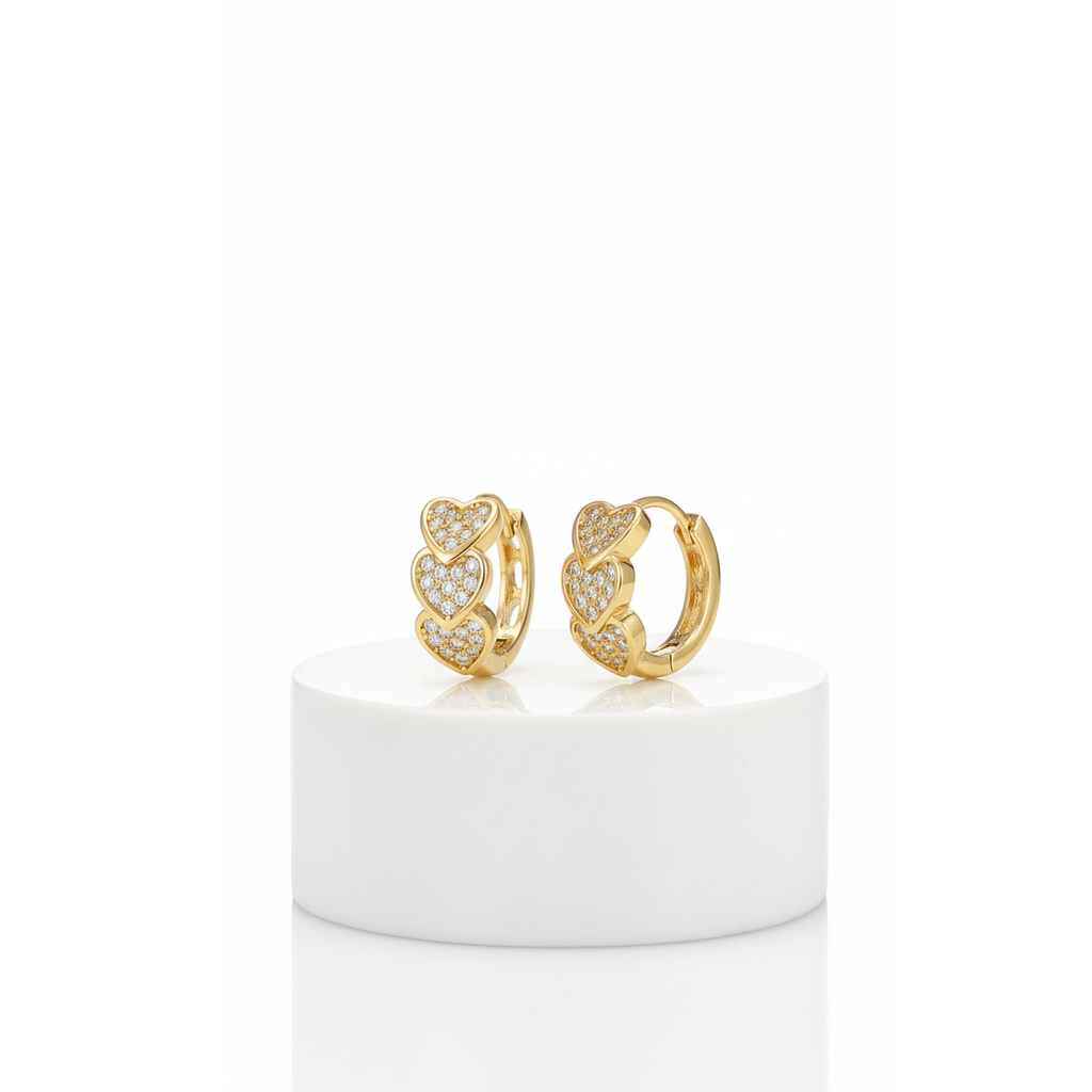 Gold Heart Crystal Cluster Hoop Earrings with heart designs on a white pedestal against a white background