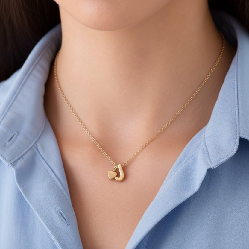 Gold Heart & J Initial Pendant Necklace pendant worn by a person.