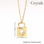 Gold Heart Padlock Necklace with a heart-shaped crystal border, shown on a white background with dimension lines indicating 15mm height, 10mm width, and weight text reading 2g Stainless Steel.