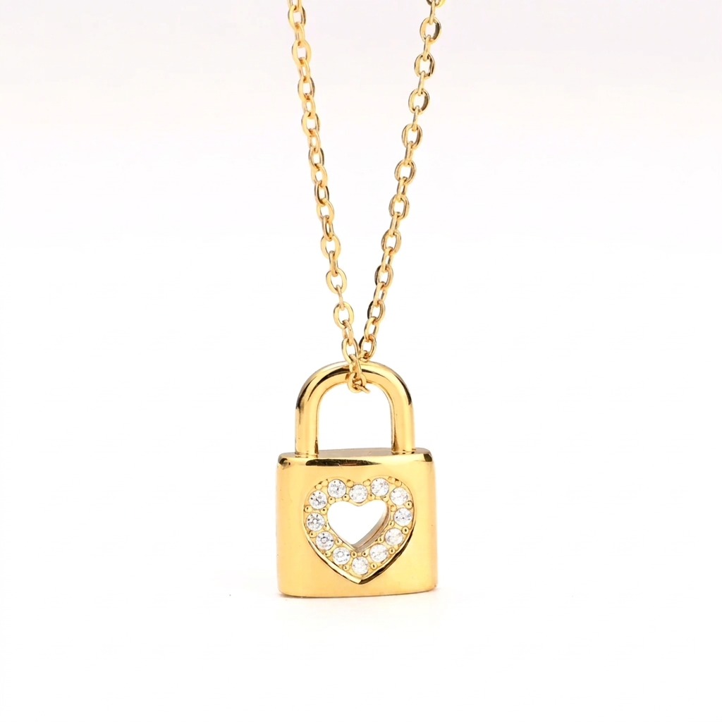 Gold Heart Padlock Necklace featuring a padlock pendant with a heart-shaped cutout adorned with small clear stones, suspended from a delicate gold chain against a plain white background.