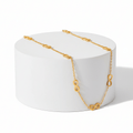 Gold Infinity Necklace on white pedestal