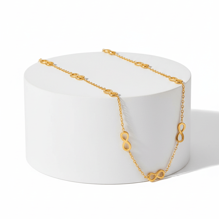 Gold Infinity Necklace on white pedestal