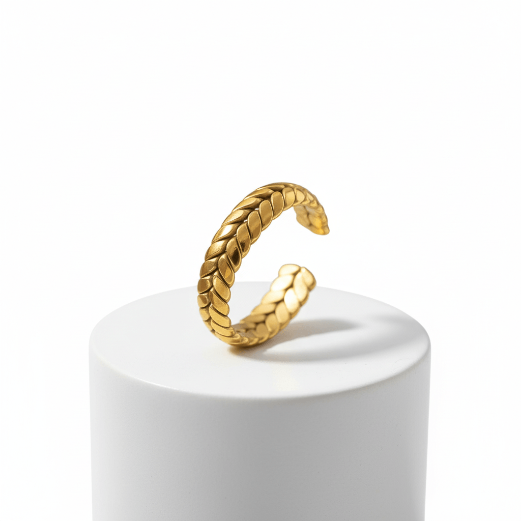 Gold Interlocking Leaf Ring displayed on a white pedestal showcasing its intricate interlocking leaf design.